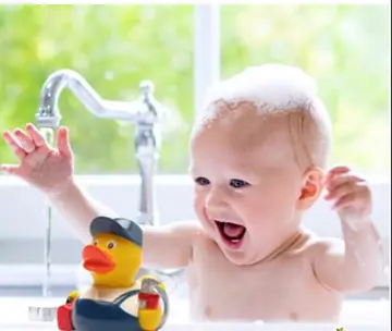 Bébé souriant dans une baignoire avec un canard en plastique